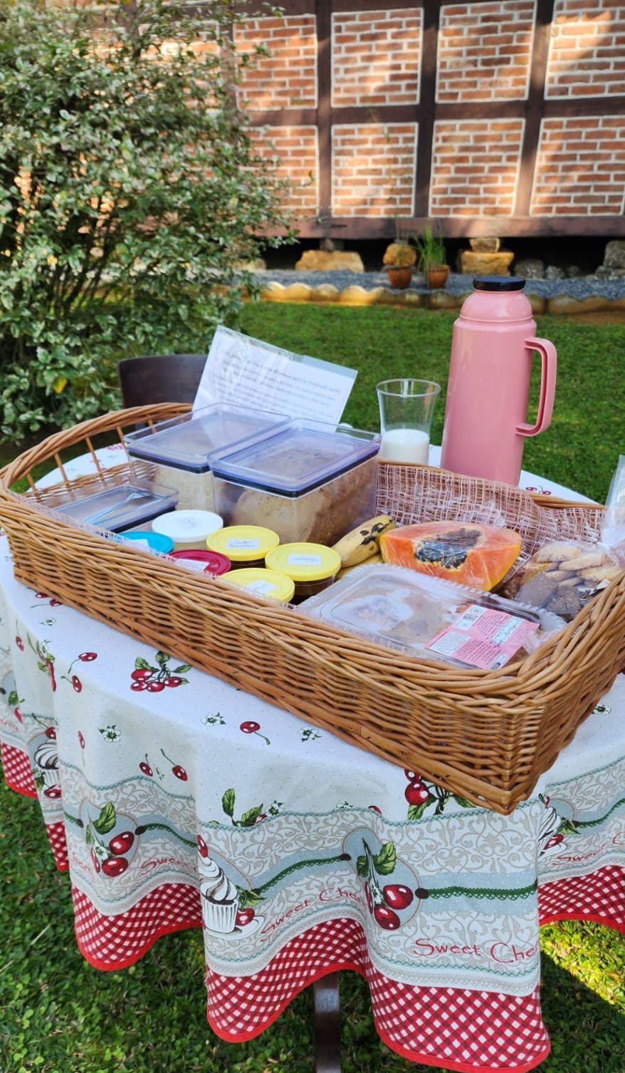 Cesta de café colonial servida no jardim da pousada